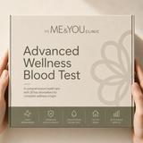 A person's hands holding a square product box for 'It's ME&YOU CLINIC Advanced Wellness Blood Test'. The box is beige with dark gray text and a gray floral graphic, with a dark gray band at the bottom containing feature icons.