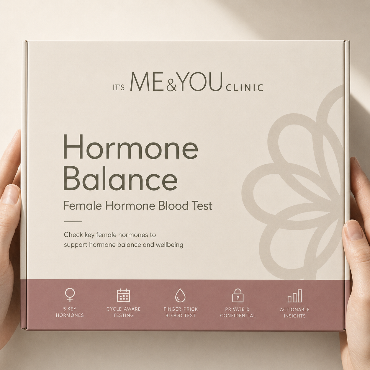 A person's hands holding a square box for the 'It's ME & YOU CLINIC' Hormone Balance Female Hormone Blood Test. The box is cream-colored with dark gray text and a dusty rose bottom banner detailing test features.